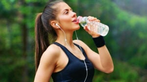 woman drinking a bottle of water to stay healthy